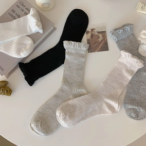Close-up of ribbed cotton socks with elegant ruffle cuffs in various neutral colors