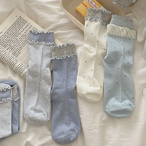 Détail de chaussettes mi-mollet pour femmes à volants avec motifs à pois et fines rayures