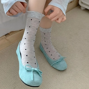 Japanese style gray polka dot socks with light blue bow ballet flats on light carpet