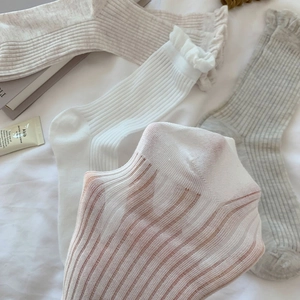Detail of ruffle cuff and ribbed cotton texture on breathable beige mid-calf socks