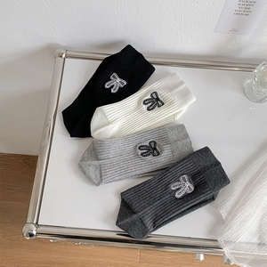 Detailed macro view of four pairs of ribbed mid-calf socks with lace bow appliques