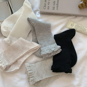 Detail of ribbed cotton mid-tube socks with elegant ruffled cuffs in four soft colors