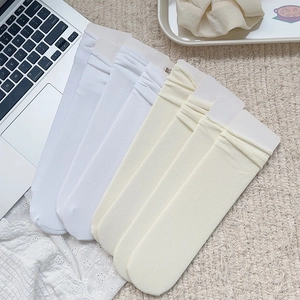 Détail de 5 paires de chaussettes en velours côtelé blanc sur un tapis doux