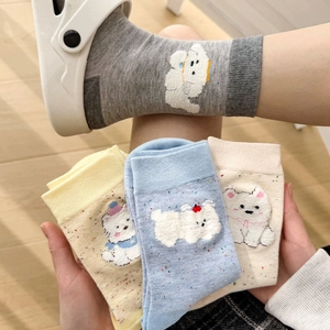 Détail de broderie chiot mignon et pois colorés sur des chaussettes en coton