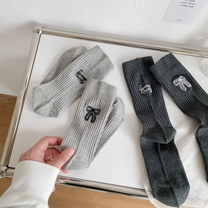 Close-up of ballet style ribbed socks with bow and Sweet Candy embroidery in a tray