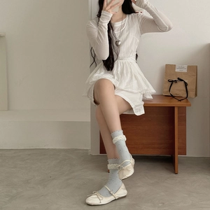 Détail de chaussettes à volants et pois bleu clair avec chaussures Mary Jane blanches