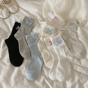 Detail of ruffled lace cuffs and delicate bow accents on Korean style cotton socks