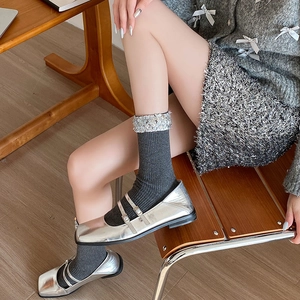 Detail of grey socks with silver sequins paired with metallic silver Mary Jane shoes