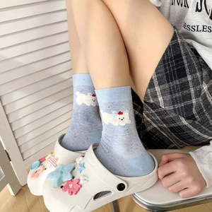 Détail de chaussettes en coton moucheté bleu clair avec broderie chiot et chaussures