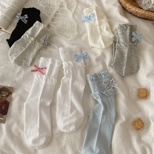 Flat lay of sweet JK style socks with ruffled lace edges and plaid bow decorations