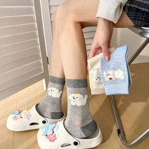 Détail de chaussettes grises en coton avec une broderie de chien blanc en 3D