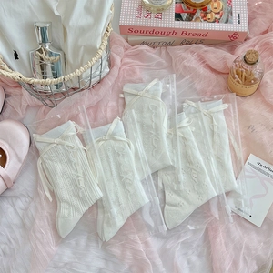 Detailed view of five pairs of white lace bow socks in elegant zipper pouch packaging
