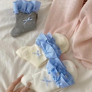 Dettaglio di pizzo a quadretti blu e fiocchi su calzini di cotone a coste da donna