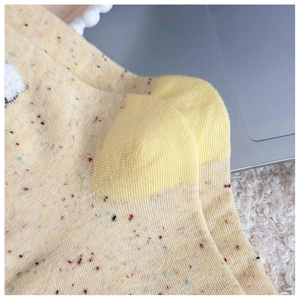 Vue macro des chaussettes jaunes mouchetées avec talon renforcé et texture douillette