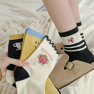 Detail of cute cartoon tomato embroidery on high-quality soft cotton socks with wavy cuffs