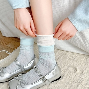 Gros plan de chaussettes en maille rayée bleu clair avec revers blancs et texture