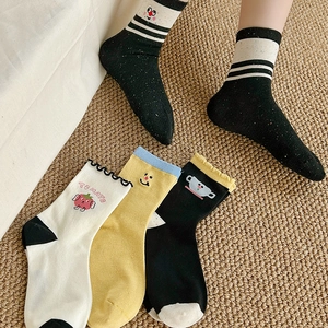 Detail of cute cartoon embroidery cotton socks with striped and tomato patterns