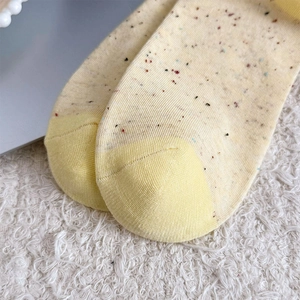 Gros plan détaillé des chaussettes en tricot jaune à pois avec couture d'orteil précise