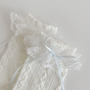 Close-up of white Lolita socks with delicate lace ruffles and a light blue silk bow detail
