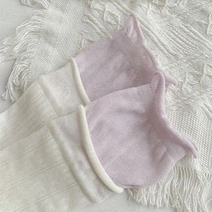 Gros plan de chaussettes plissées côtelées crème et lavande avec bordure roulée douce
