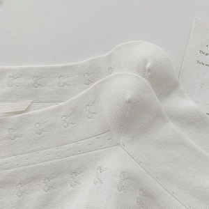 Gros plan de chaussettes blanches avec texture maille cœur et bords ondulés délicats