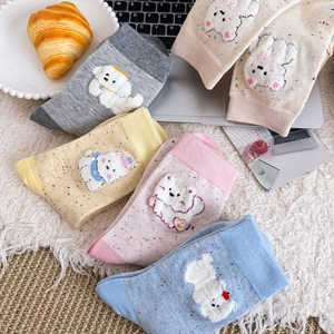Gros plan de chaussettes en coton moucheté avec broderie de chiot en peluche 3D mignonne