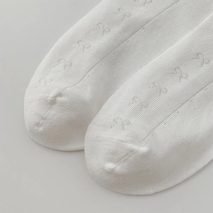 Détails de chaussettes blanches en résille avec jacquard nœud et maille ajourée respirante
