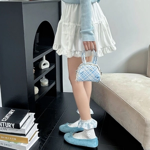 Détail du sac à main à carreaux bleu clair avec dentelle et chaussures à nœud sur modèle