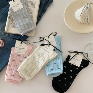 Detail of five pairs of heart-patterned crew socks in various pastel and neutral tones