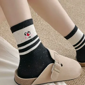 Detail of black and white striped socks with cute cartoon embroidery and lace trim