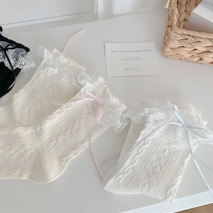 Detail of white Lolita socks featuring delicate lace edges and soft ribbon bows