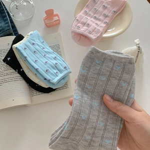 Detail showing the soft knitted texture and colorful heart patterns on sweet cotton socks