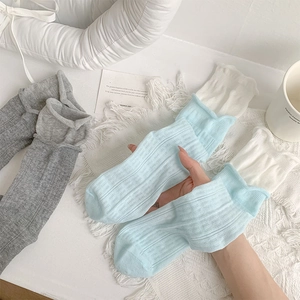 Détail de la texture côtelée et des poignets à volants sur chaussettes plissées style ballet