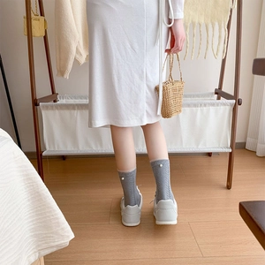 Close-up of grey cable knit mid-calf socks with elegant white pearl detail at the cuff