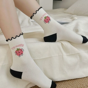 Detailed embroidery of a cute tomato character on cream-white cotton socks with frilly lace