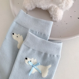 Dettaglio calzino azzurro con motivo a cane e fiocco in nastro blu con effetto 3D