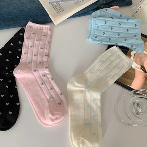 Close-up of ribbed cotton socks in pastel colors with heart patterns in a cozy setting
