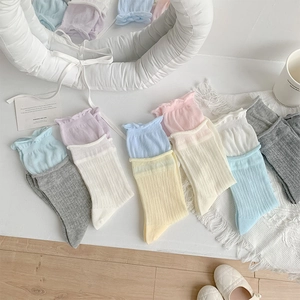 Détail de chaussettes style ballerine colorées avec bords à volants et maille côtelée