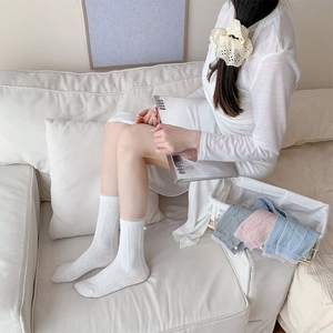 Detail of white lace trim socks with heart pattern and pearl pendant decoration