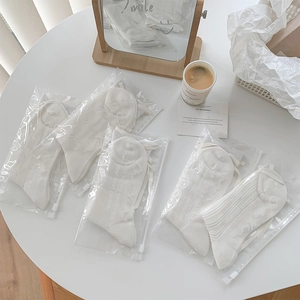 Détail de 5 paires de chaussettes blanches ajourées avec rubans et sachets cadeaux