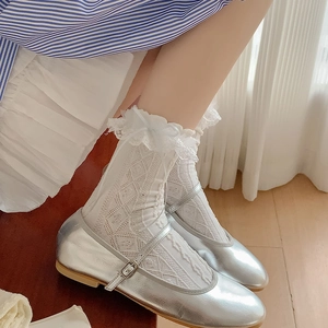Detail of white Lolita lace socks with ribbon bows paired with silver Mary Jane shoes