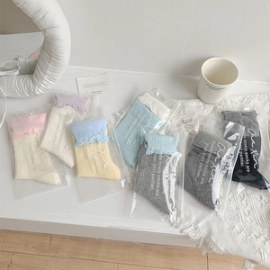 Détail de chaussettes colorées style ballerine en sachets zippés avec bords ondulés