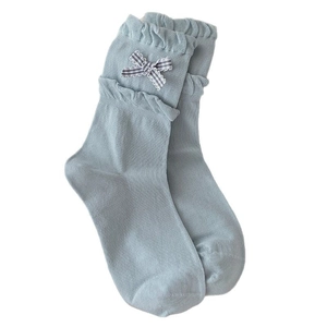 Light blue knit crew socks with ruffled edges and black and white plaid bow decoration