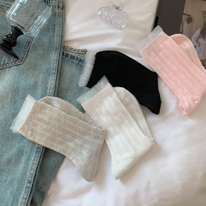 Détail de chaussettes en tricot à bordure en dentelle aux tons pastel et textures