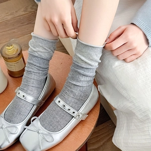Détail de chaussures Mary Jane argentées avec nœud et chaussettes grises