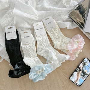 Détail de chaussettes enfant en coton avec bordures en dentelle et maille torsadée