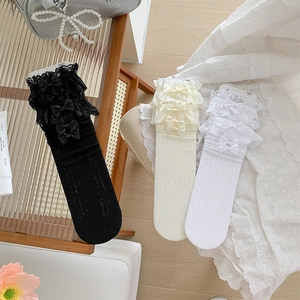 Detailed view of lace trim mesh socks with satin bows and hollow heart patterns