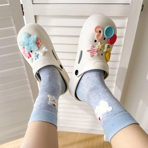 Gros plan de chaussettes à motifs de chiens avec des sabots blancs décorés