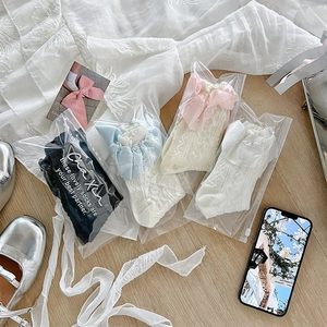Détail de quatre paires de chaussettes Lolita en dentelle avec grands nœuds en soie