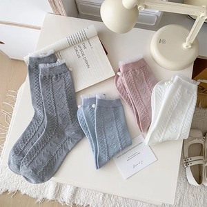 Detail of heart patterns, lace edges and pearl accents on four color crew socks